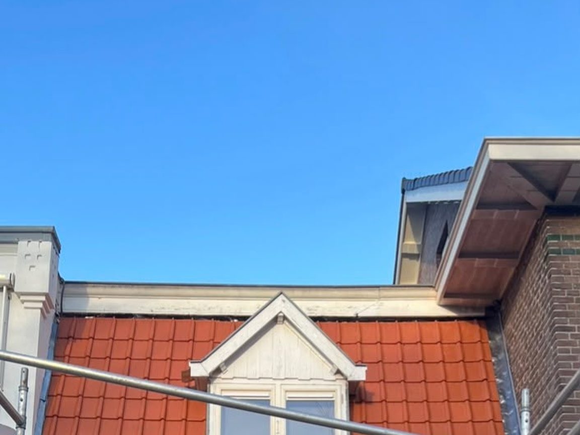 Dakkapel op een pannendak in Bloemendaal, met steiger langs de gevel tijdens de renovatie
